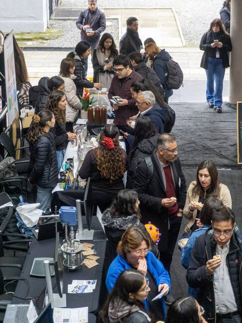 Un grupo de personas en un evento con mesas de comida y bebida en un ambiente de networking.
