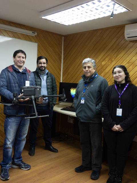 Un grupo de personas sostiene un dron en una sala de reuniones.