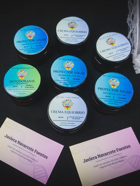 Una variedad de productos cosméticos en frascos, incluyendo desodorante y protector solar, acompañados de tarjetas de contacto.