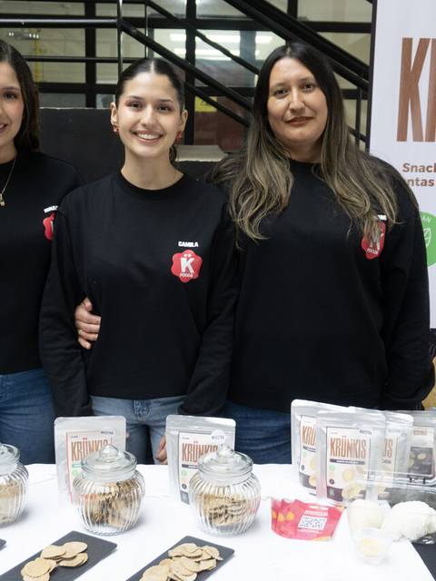 Tres emprendedoras chilenas promocionando snacks saludables en un evento.