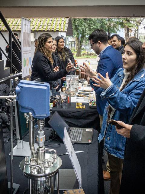 Un grupo de personas interactuando en una feria con productos y tecnología.