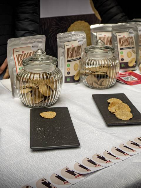 Mesa con galletas y snacks típicos chilenos expuestos en frascos y platos.