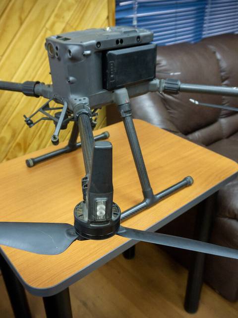 Un dron militar posado sobre una mesa en un ambiente interior.