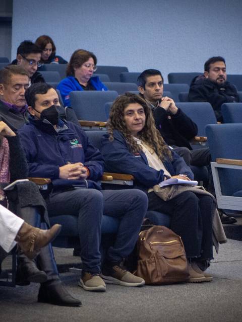 Un grupo de personas atentas en una charla en un auditorio.