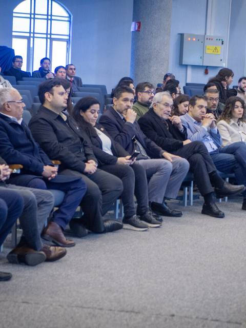 Un grupo de personas participando en un evento en una sala de conferencias.