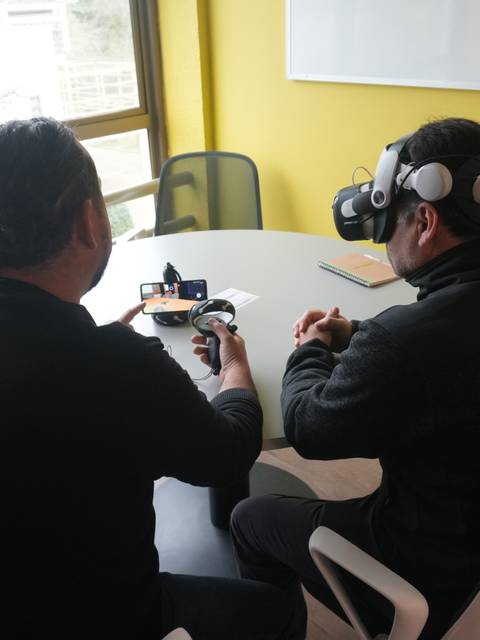 Dos personas interactuando en una sesión de realidad virtual en una oficina.