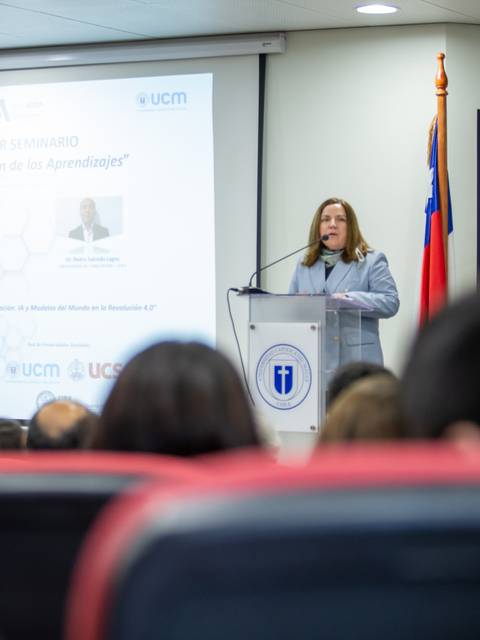 Una mujer está dando una charla en un seminario en Chile.