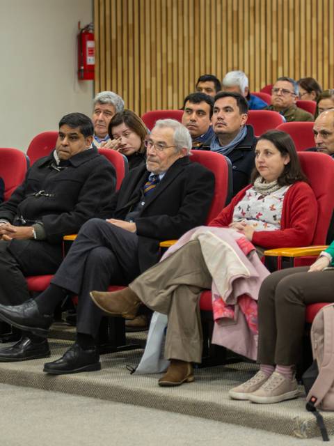 Un grupo de personas sentadas en un salón durante una charla.