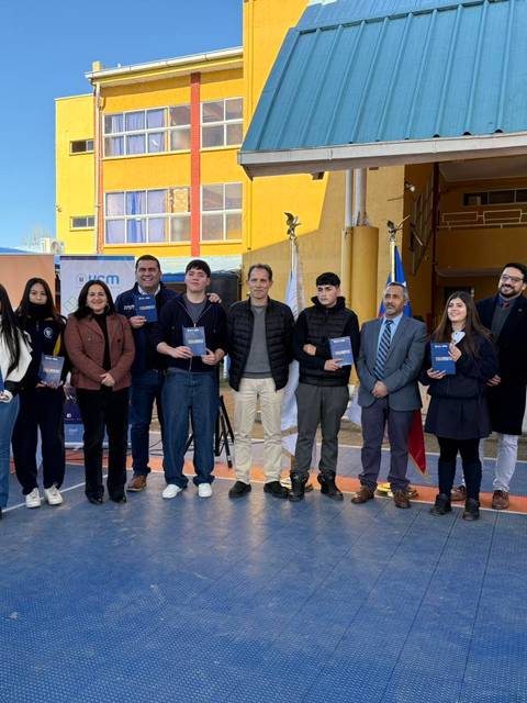 Un grupo de personas en un acto de entrega de certificados en una escuela chilena.
