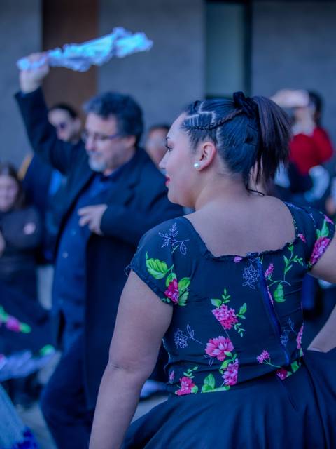Un grupo de personas bailando en una celebración chilena al aire libre.