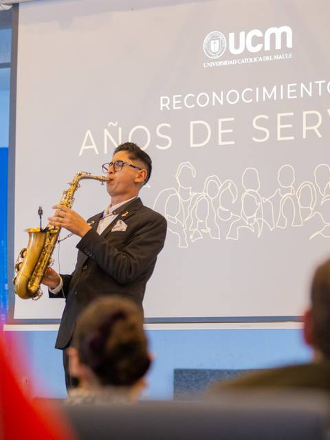 Un joven tocando saxofón en un evento de reconocimiento.