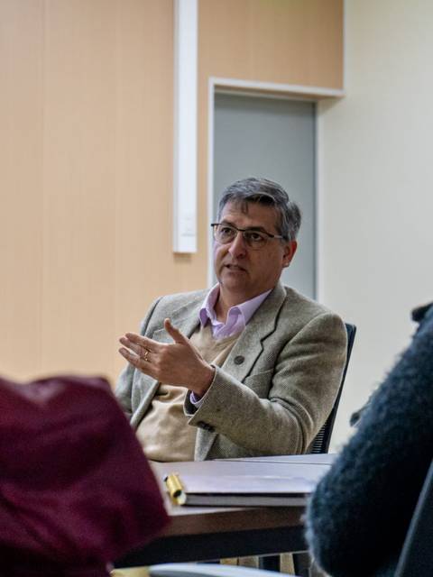 Un grupo de personas escucha atentamente a un expositor en una reunión.