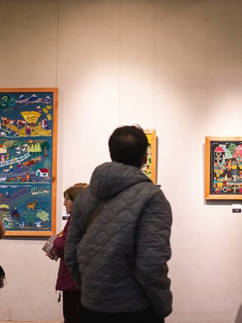 Varias personas disfrutando de una exposición de arte en una galería.