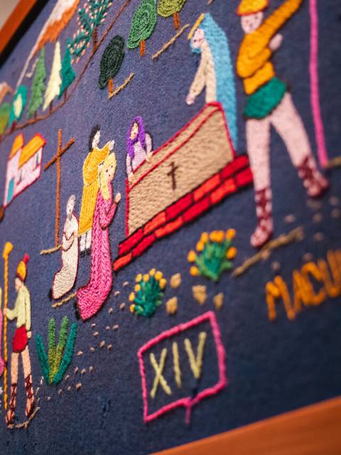 Un colorido bordado chileno que representa escenas rurales y tradiciones del país.