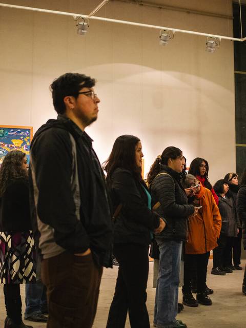 Un grupo de personas observando obras de arte en una galería.