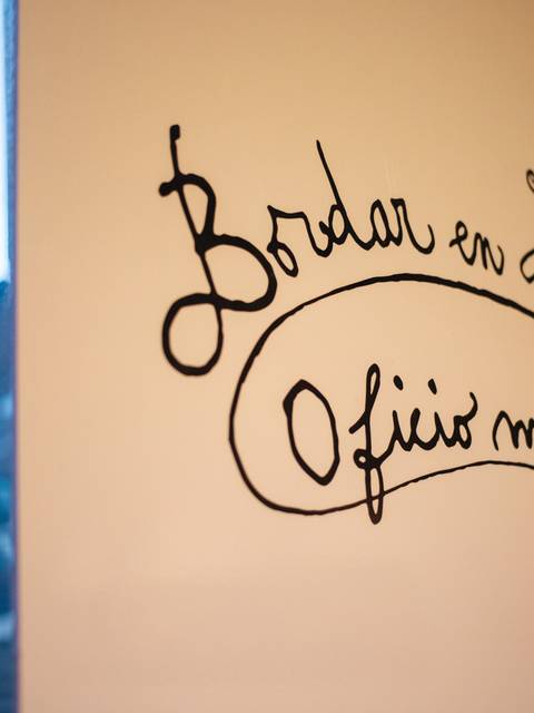 Un mural con un diseño caligráfico que destaca el arte de bordar en Huilquilemu.