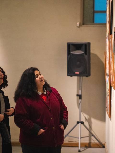 Un par de personas observando atentamente las obras de arte en una galería.