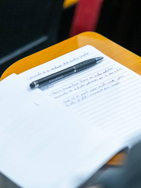 Una libreta con notas escritas y un lápiz sobre una mesa.