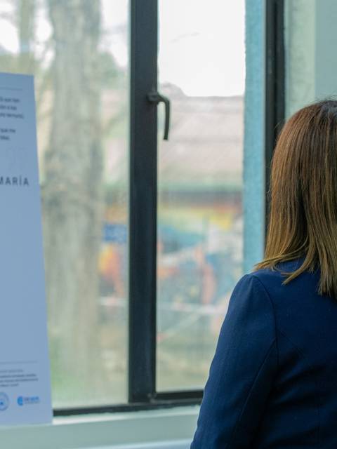 Una mujer observa una fotografía en una exposición que muestra a Doña María y su perro.