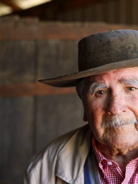 Un hombre mayor con sombrero y chaqueta, retratado en un ambiente rural chileno.