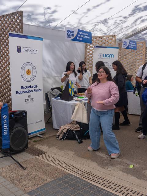 Estudiantes disfrutando de una actividad de baile en una feria universitaria.