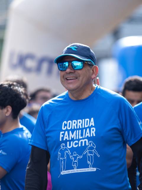 Un grupo de personas sonrientes participa en una corrida familiar en la calle.