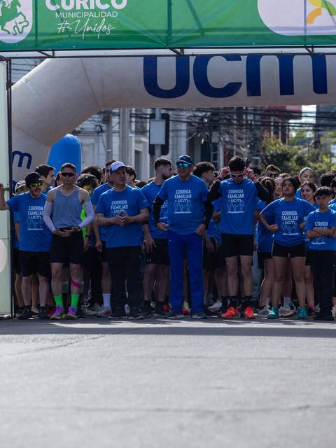 Un grupo de personas vestidas de azul se prepara para una carrera en Curicó.