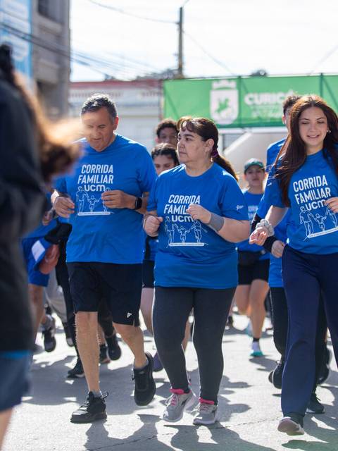 Un grupo de personas participando en una corrida familiar en la calle.