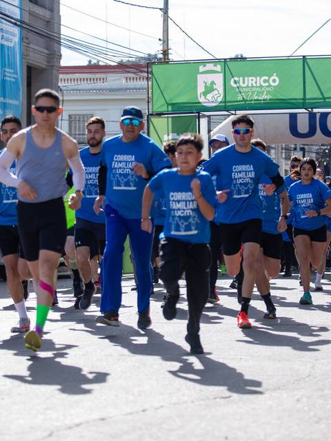 Un grupo de corredores con poleras azules participa en una carrera en Curicó.