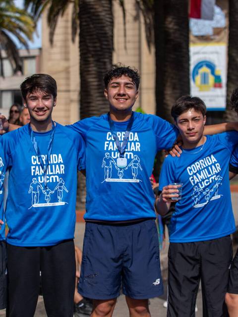 Un grupo de amigos sonríen felices después de participar en una corrida familiar.