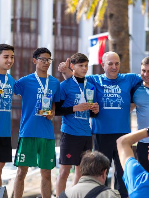 Un grupo de ganadores sonríen con medallas en un evento familiar en Chile.