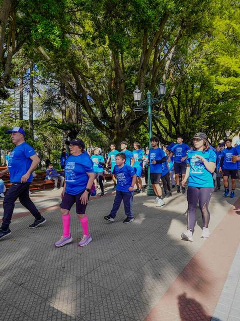 Un grupo de personas con camisetas azules participando en una actividad deportiva al aire libre.