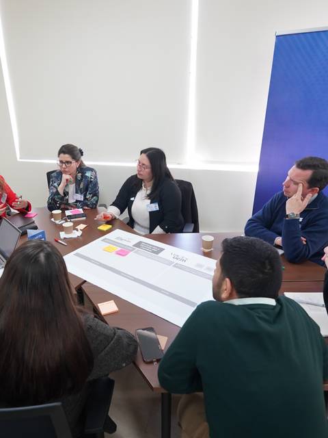 Grupo de personas discutiendo en una reunión en la Universidad Católica de Maule.