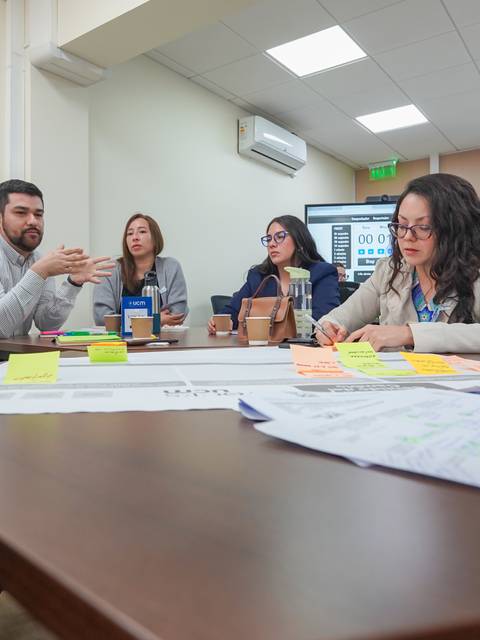 Un grupo de personas discutiendo en una reunión colaborativa.