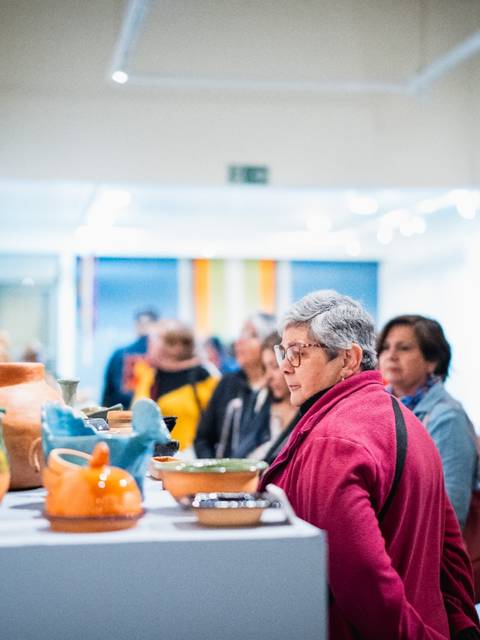 Gente disfrutando de una exposición de artesanía en un museo.