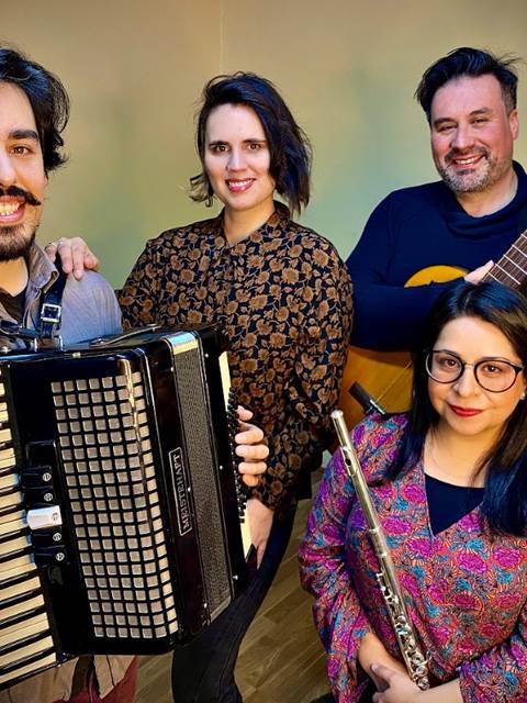 Un grupo de músicos chilenos posando con instrumentos en un ambiente acogedor.