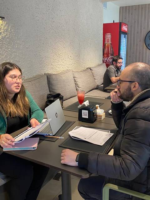Una conversación entre dos personas en una cafetería moderna.