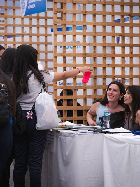 Un grupo de personas interactuando en un stand durante un evento en Chile.
