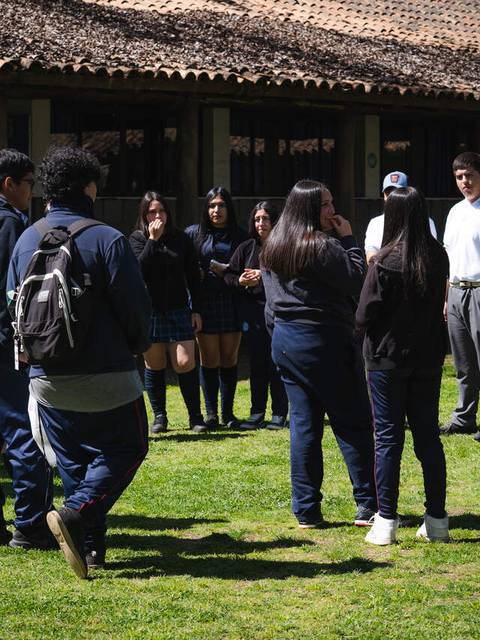 Un grupo de estudiantes conversando en el patio de una escuela.