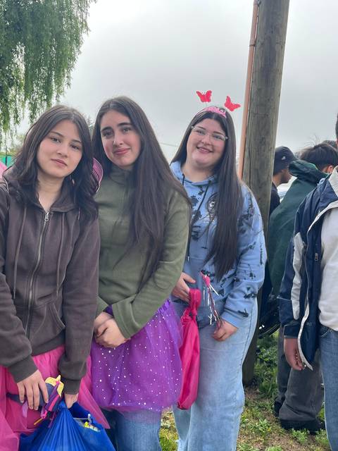 Un grupo de amigos se divierten en una celebración, luciendo trajes coloridos y sonrisas.
