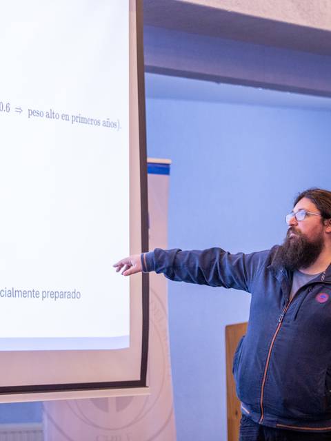 Un expositor presenta una gráfica durante una charla en un evento académico en Chile.
