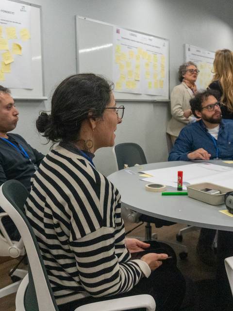 Un grupo de personas participando en una dinámica de trabajo colaborativo en una sala de reuniones.