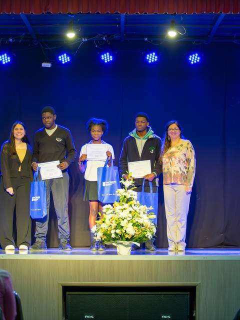 Celebración de entrega de certificados a participantes del programa de español para migrantes en un escenario de la UCM.