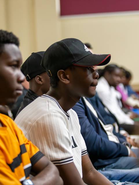 Un grupo de jóvenes sentados atentos en una charla o evento.