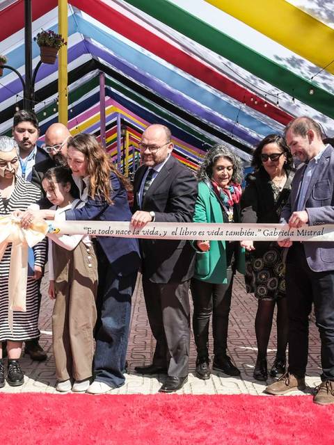 Inauguración de una feria cultural con un colorido toldo.