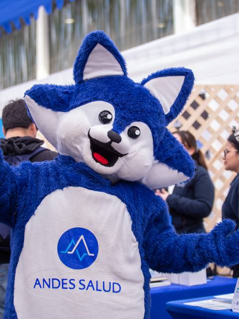 Un personaje disfrazado de zorro azul promocionando Andes Salud en un evento.