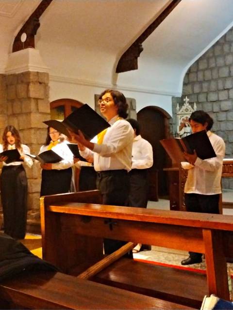 Un grupo de personas canta en una iglesia con una atmósfera acogedora.