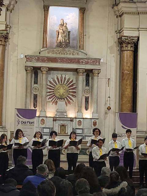 Un grupo de personas canta en un hermoso recinto religioso.