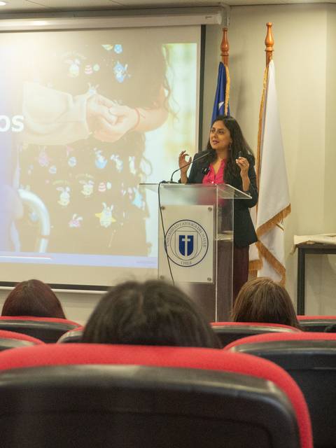 Mujer exponiendo en una conferencia sobre cuidados en Chile.