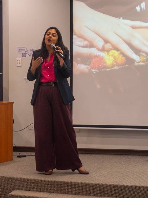 Una mujer exponiendo sobre el cuidado humano en una presentación.